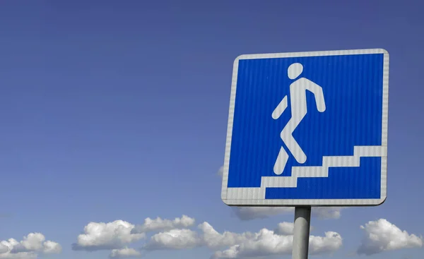 stock image Underpass sign pointer on the background of the sky with clouds