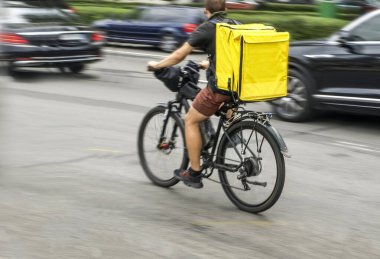 Motion blur, a courier on a bicycle is in a hurry to deliver an order