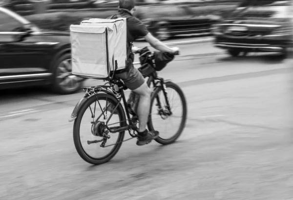 モーション ブラー自転車の宅配便が注文を出すために急いでいる — ストック写真