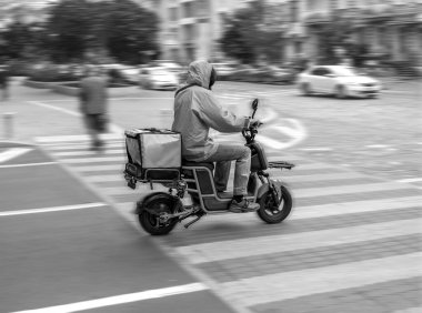Güç bulanık görüntüsü, elektrikli scooter 'daki kurye siparişi yerine getirmek için acele ediyor.