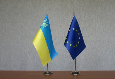 Gri arka planda Ukrayna ve Avrupa Birliği 'nin masa üstü bayrakları
