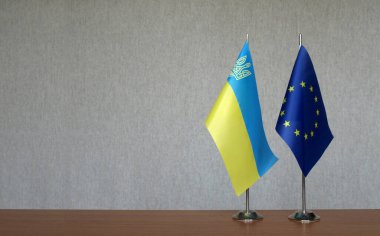 Gri arka planda Ukrayna ve Avrupa Birliği 'nin masa üstü bayrakları