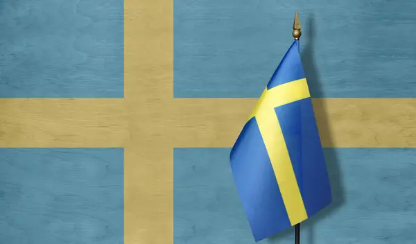 A small Swedish flag with a pale image of the Swedish flag in the background
