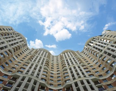 Gökyüzüne karşı çok katlı bir binanın dalgalı cephesi