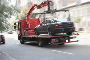 Motion blur, car tow truck rides on a city street clipart