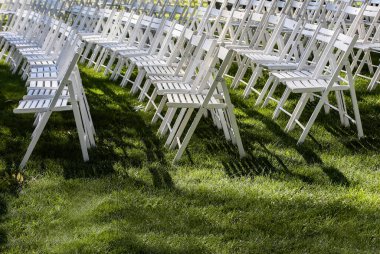 Parktaki çimlerin üzerinde seyirciler için katlanır ahşap sandalyeler.