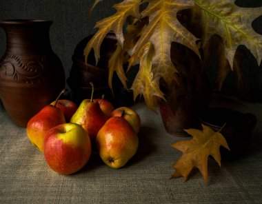 Kırmızı elmalar, kuru meşe yaprakları ve seramik tabaklarla sonbahar kompozisyonu