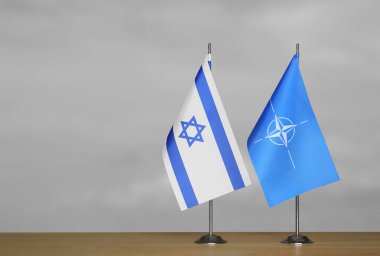 Gri arkaplanda İsrail ve NATO bayrakları