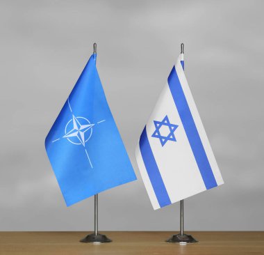 Gri arkaplanda İsrail ve NATO bayrakları