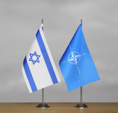 Gri arkaplanda İsrail ve NATO bayrakları