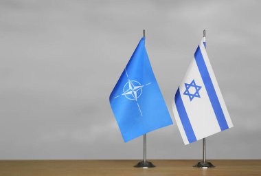 Gri arkaplanda İsrail ve NATO bayrakları
