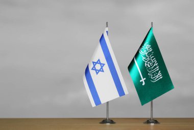 Gri arka planda İsrail ve Suudi Arabistan bayrakları