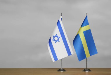 Gri arka planda İsveç ve İsrail 'in bayrakları
