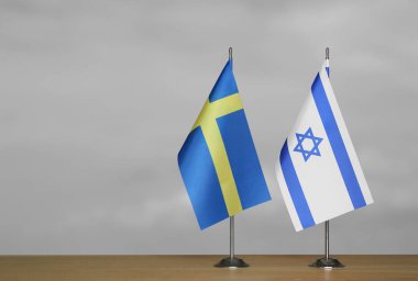 Gri arka planda İsveç ve İsrail 'in bayrakları