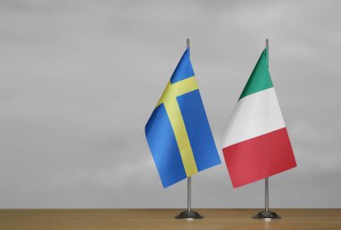 Gri arka planda İsveç ve İtalya 'nın bayrakları