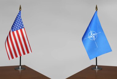 ABD ve NATO bayrakları gri arka planda duruyor