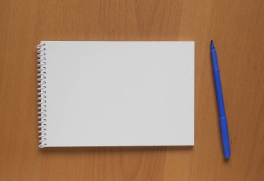 Masanın üzerinde açık bir defter ve keçeli kalem.