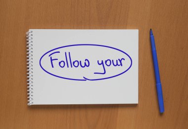 Üzerinde yazı olan açık bir defter; Masadaki keçeli kaleminizi ve kaleminizi takip edin