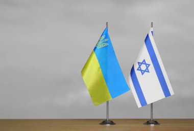 Ukrayna ve İsrail 'in masa üstü bayrakları gri, bulanık bir sırt grubunda