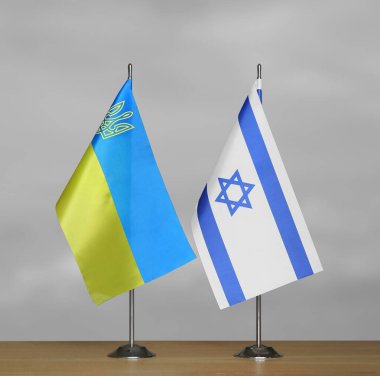 Ukrayna ve İsrail 'in masa üstü bayrakları gri, bulanık bir sırt grubunda
