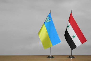 Gri arkaplanda Ukrayna ve Suriye 'nin masa üstü bayrakları