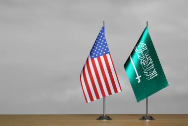 Gri arka planda ABD ve Suudi Arabistan 'ın masa üstü bayrakları