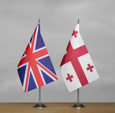 Gri arkaplanda Birleşik Krallık ve Gürcistan bayrakları