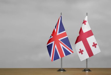 Gri arkaplanda Birleşik Krallık ve Gürcistan bayrakları
