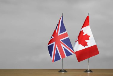 Gri arkaplanda Birleşik Krallık ve Kanada bayrakları