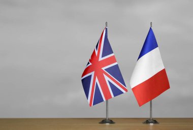 Gri arkaplanda Birleşik Krallık ve Fransa bayrakları