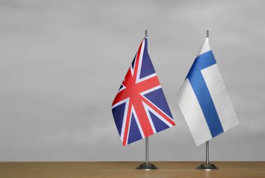 Gri arka planda Birleşik Krallık ve Finlandiya bayrakları