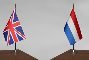 Birleşik Krallık ve Hollanda 'nın masa üstü bayrakları gri bir arka planda duruyor