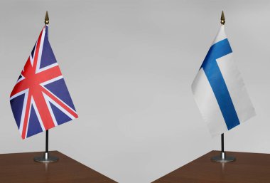 Birleşik Krallık ve Finlandiya 'nın bayrakları gri arka planda duruyor