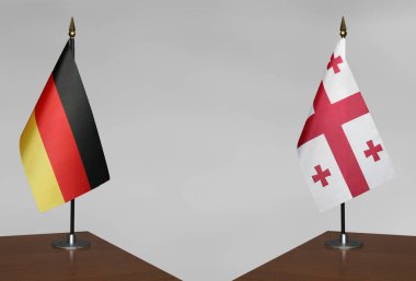 Almanya ve Gürcistan 'ın bayrakları gri arka planda duruyor