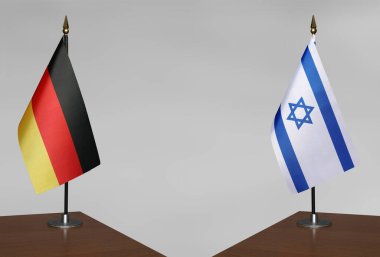 Almanya ve İsrail 'in bayrakları gri arka planda duruyor