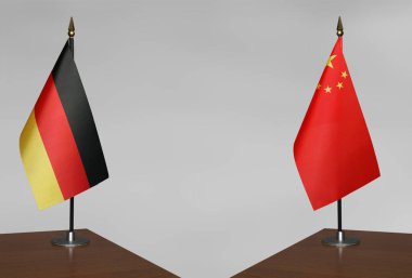 Almanya ve Çin 'in bayrakları gri arka planda duruyor