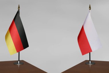 Almanya ve Polonya 'nın bayrakları gri arka planda duruyor