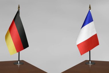 Almanya ve Fransa 'nın bayrakları gri arka planda duruyor