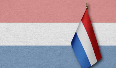 Arka planda Hollanda bayrağının soluk bir görüntüsü olan küçük bir Hollanda bayrağı