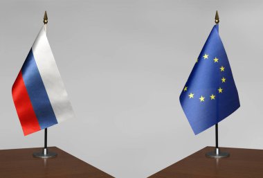 Avrupa Birliği ve Rusya 'nın bayrakları gri arka planda duruyor