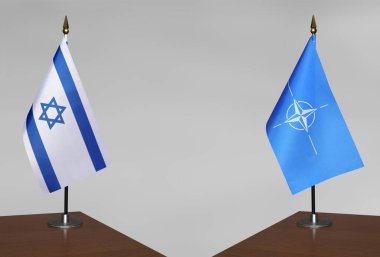 İsrail ve NATO 'nun bayrakları gri arka planda duruyor
