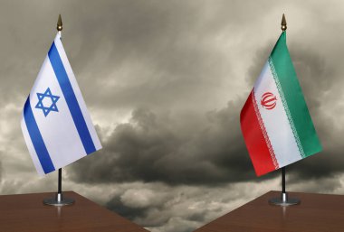 Masa İsrail ve İran 'ı işaret ediyor. Arka planda fırtınalı bir gökyüzü var.