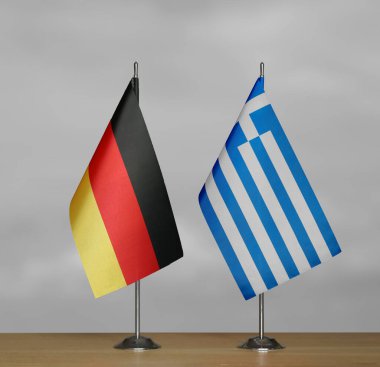 Almanya ve Yunanistan 'ın bayrakları gri arka planda duruyor