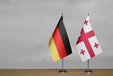 Almanya ve Gürcistan 'ın bayrakları gri arka planda duruyor