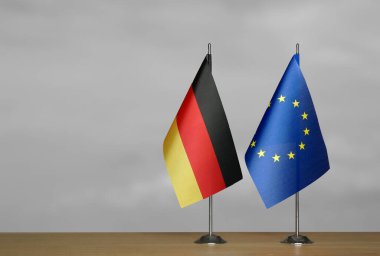 Almanya ve Avrupa Birliği 'nin bayrakları gri arka planda duruyor