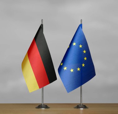 Almanya ve Avrupa Birliği 'nin bayrakları gri arka planda duruyor