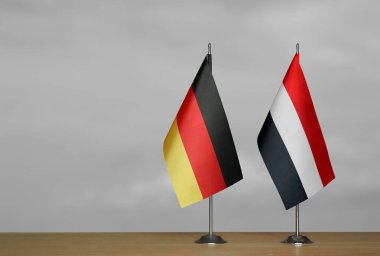 Almanya ve Yemen Cumhuriyeti 'nin bayrakları gri arka planda duruyor