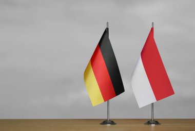 Almanya ve Endonezya 'nın bayrakları gri arka planda duruyor