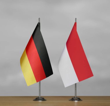 Almanya ve Endonezya 'nın bayrakları gri arka planda duruyor