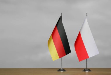 Almanya ve Polonya 'nın bayrakları gri arka planda duruyor